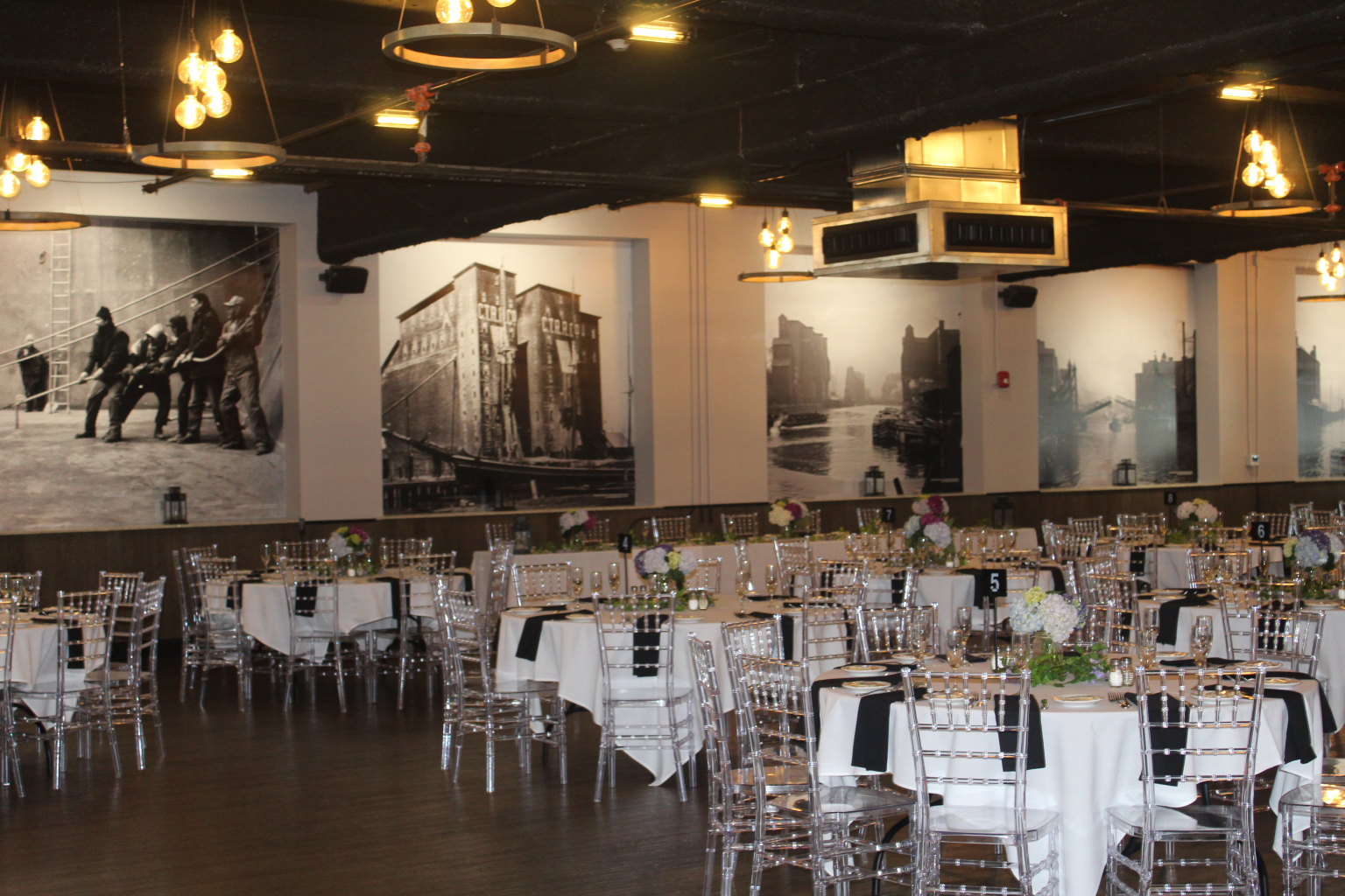 Guest tables set with black napkins across the Silos Event Center floor