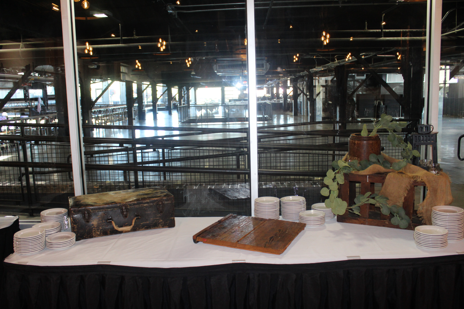 Serving station with stacked plates and a carving board set above the rink floor