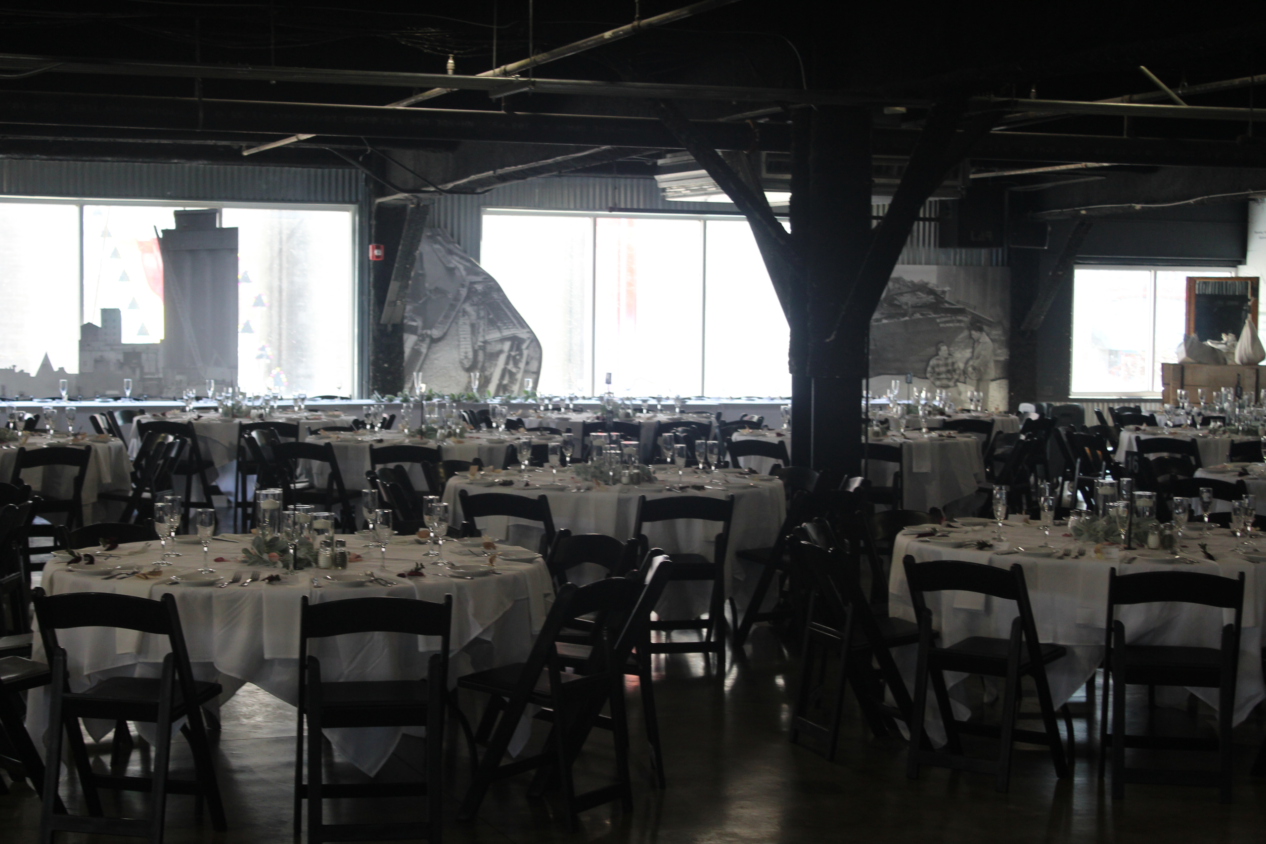 Round banquet tables set under the steel structure of the Upper Mezzanine