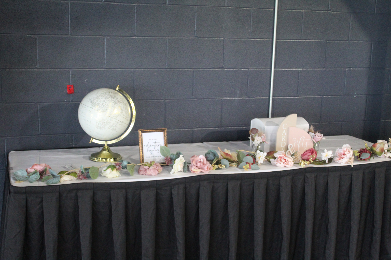 Draped display table dressed with flowers and a globe