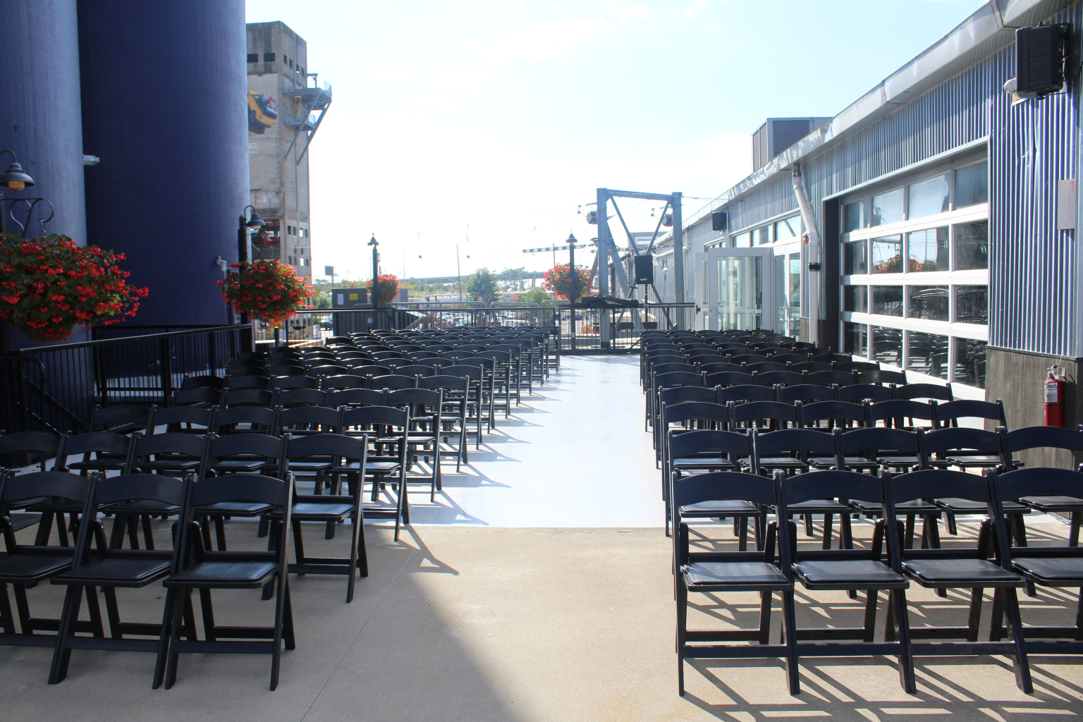 Ceremony chairs set in rows on the second story patio of the Upper Mezzanine above the water