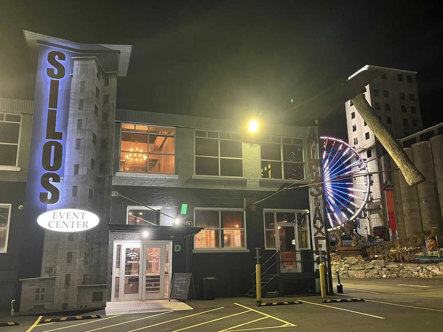 The lit Silos entrance sign on the side of the building at night