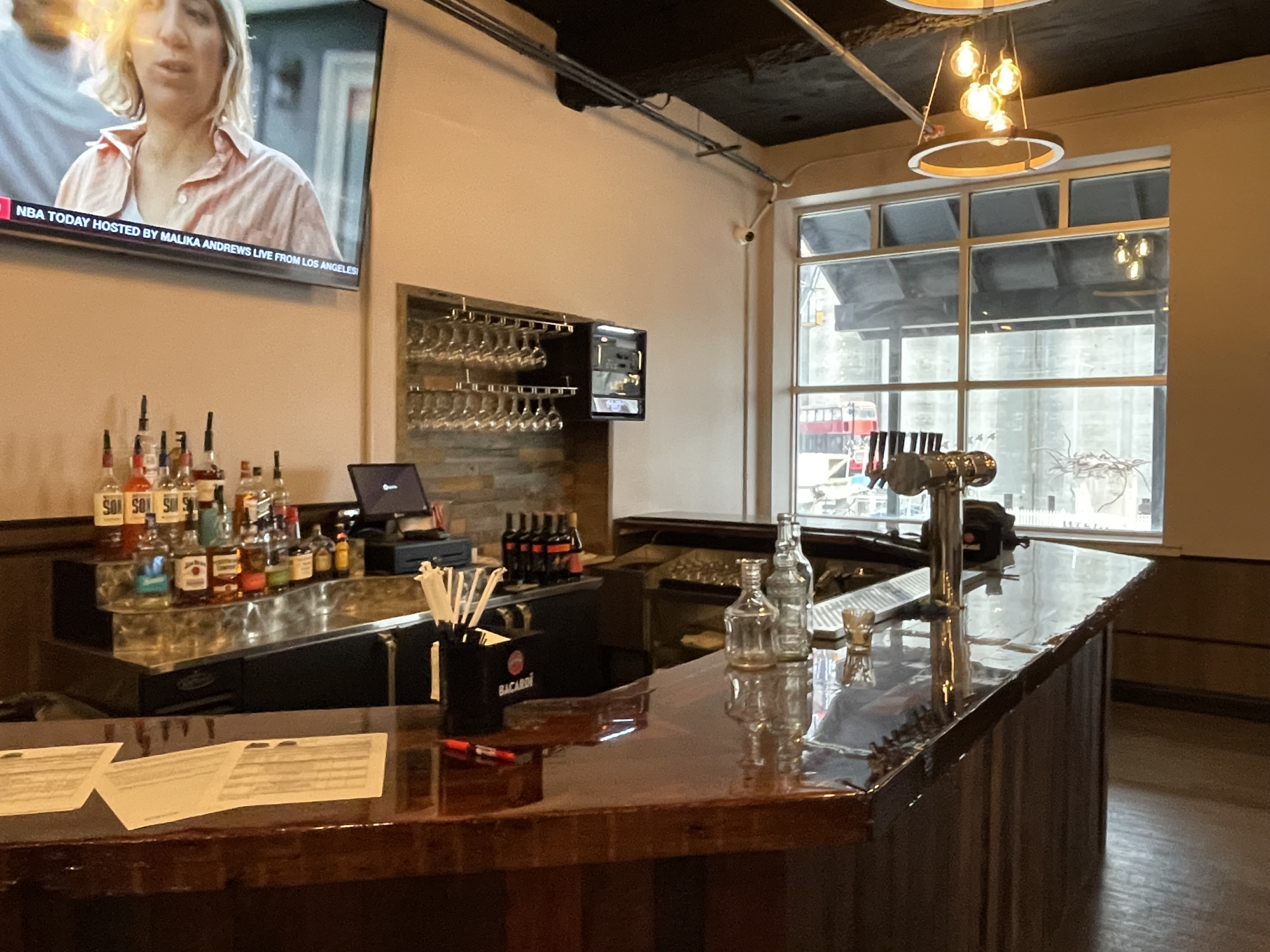 The full bar in the Silos Event Center with bottles, taps and a screen above it