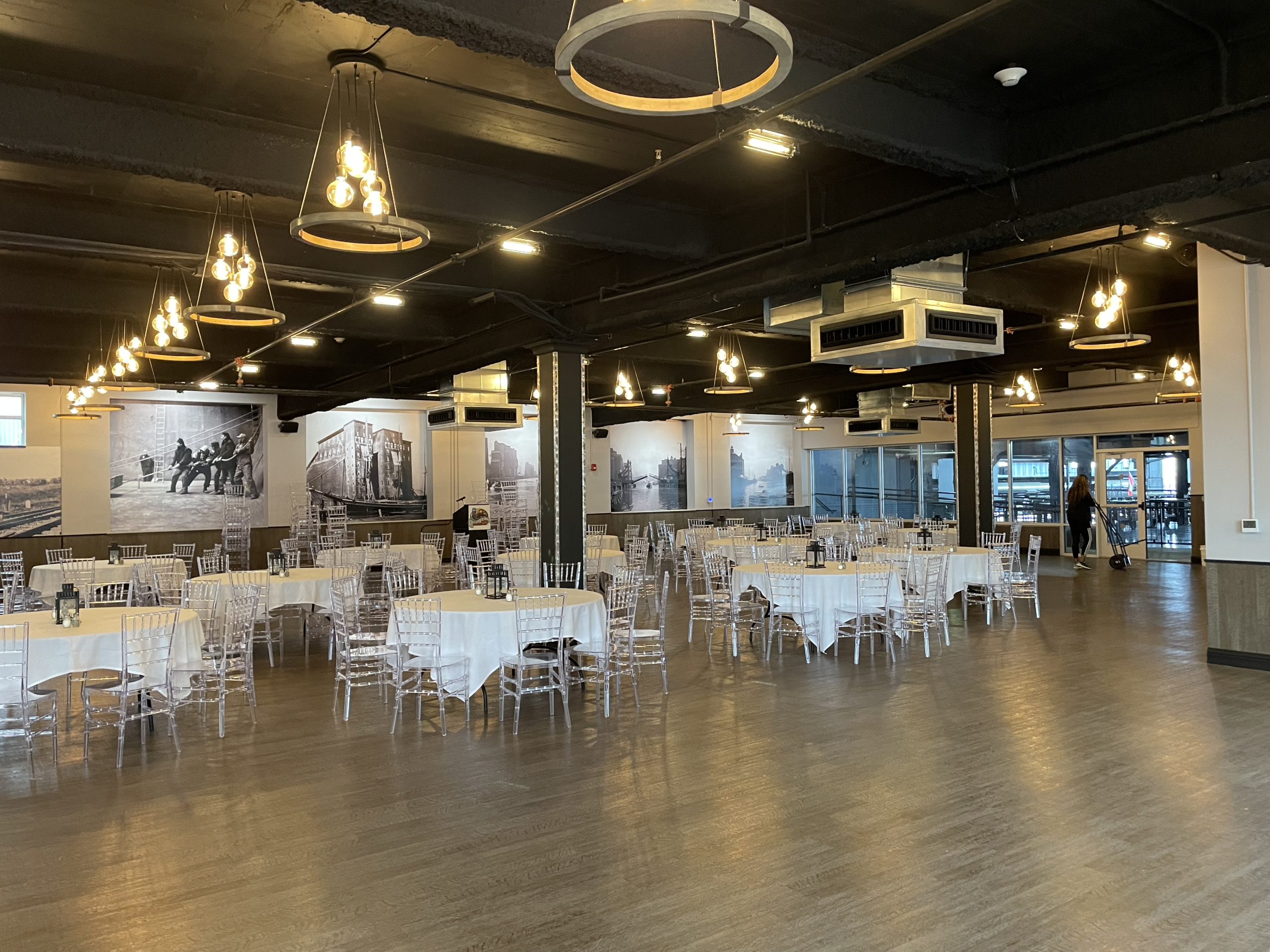 Round tables and white chairs set through the room beside the picture windows