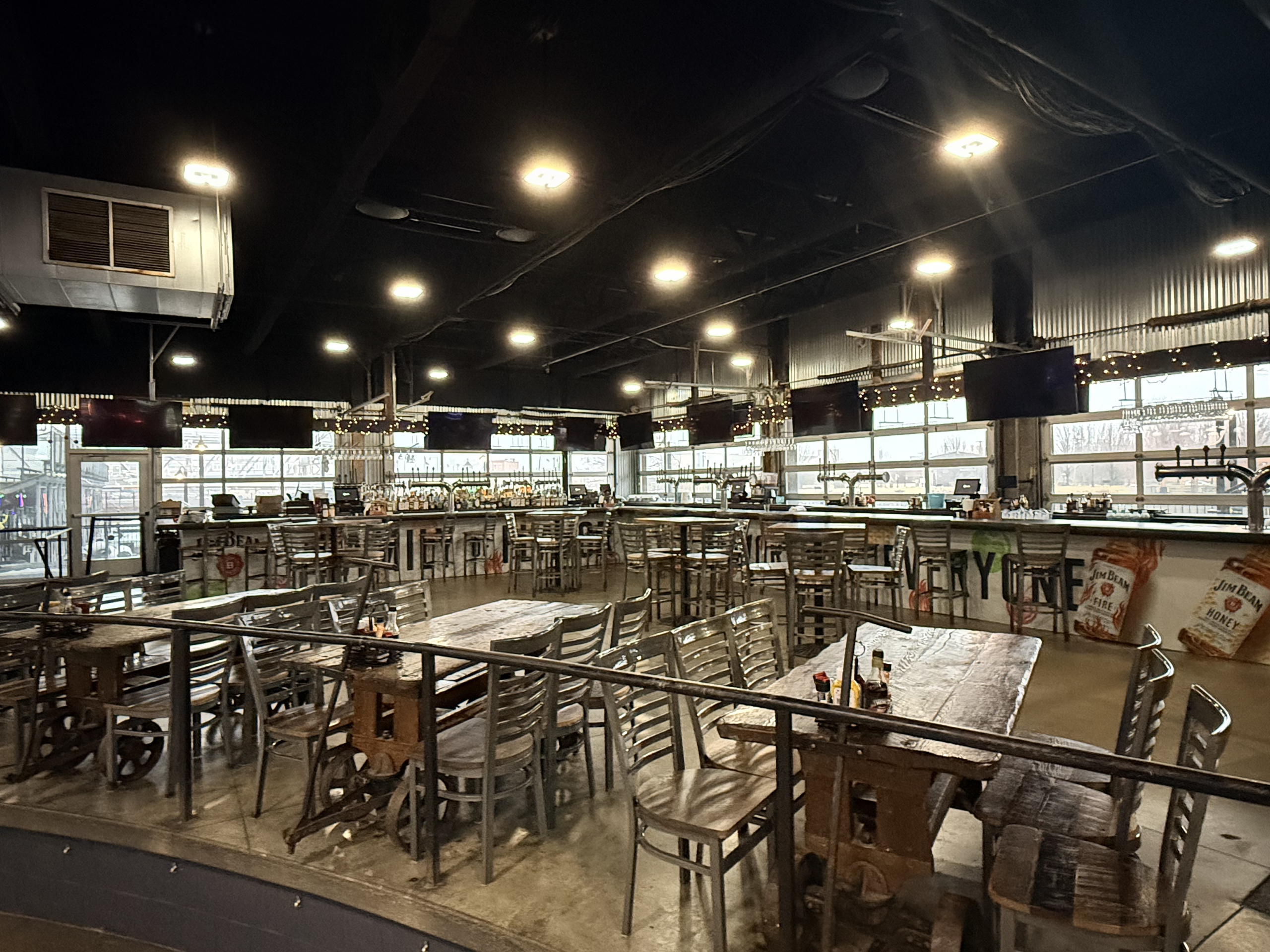The Ward main bar at Buffalo RiverWorks with high top tables and window seating