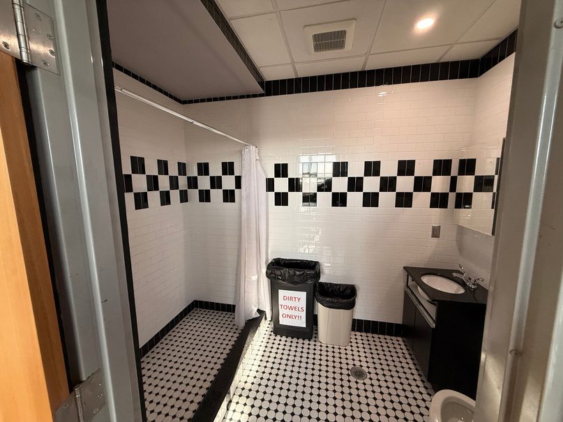 Private shower room with black and white tile.